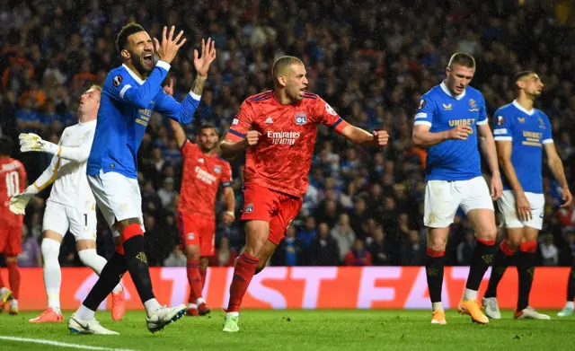 Lyon's Algerian forward Islam Slimani (R) celebrates after Rangers' English defender James Tavernier scored an own goal