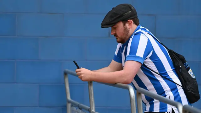 Huddersfield fan on his phone