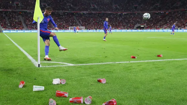 Mason Mount takes a corner surrounded by cups thrown from the crowd