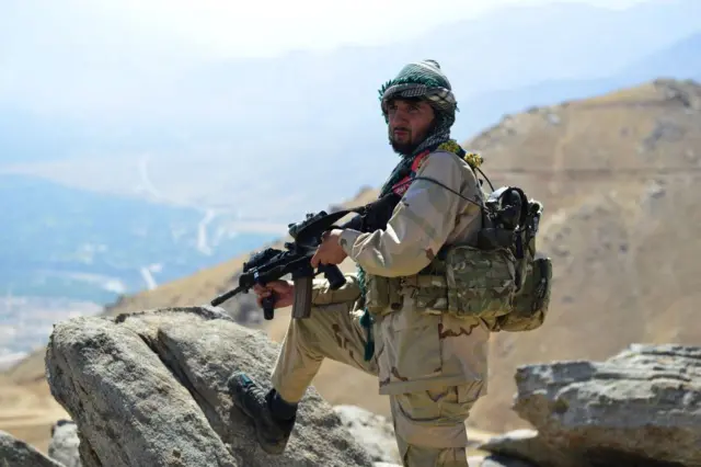 A member of the Afghan resistance patrols on a hilltop in Panjshir