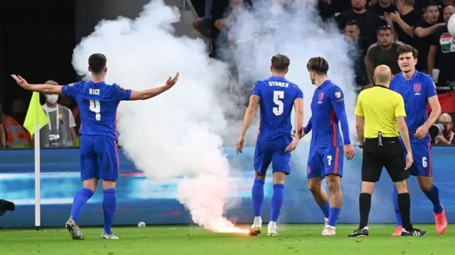 England players with a flare on the pitch