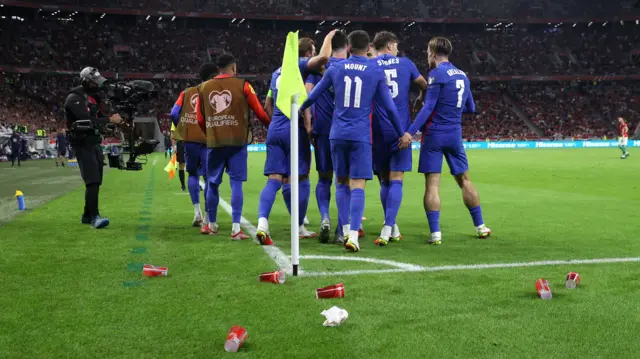 England players celebrate surrounded by cups thrown from the crowd