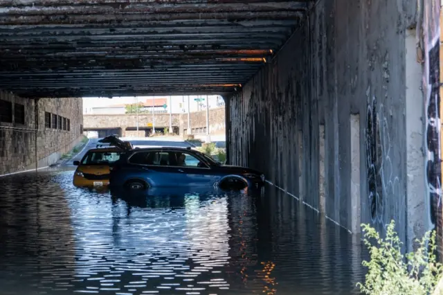 Cars are left stranded in flood water under a bridge in New York City