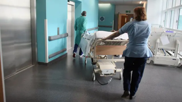 Hospital staff with bed