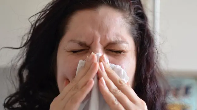 A woman sneezes