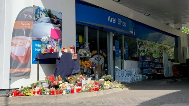 Flowers have been laid outside the petrol station where the student was shot