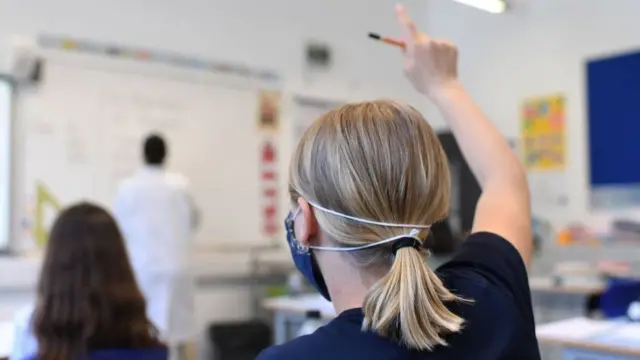 A pupil wears a face mask in class