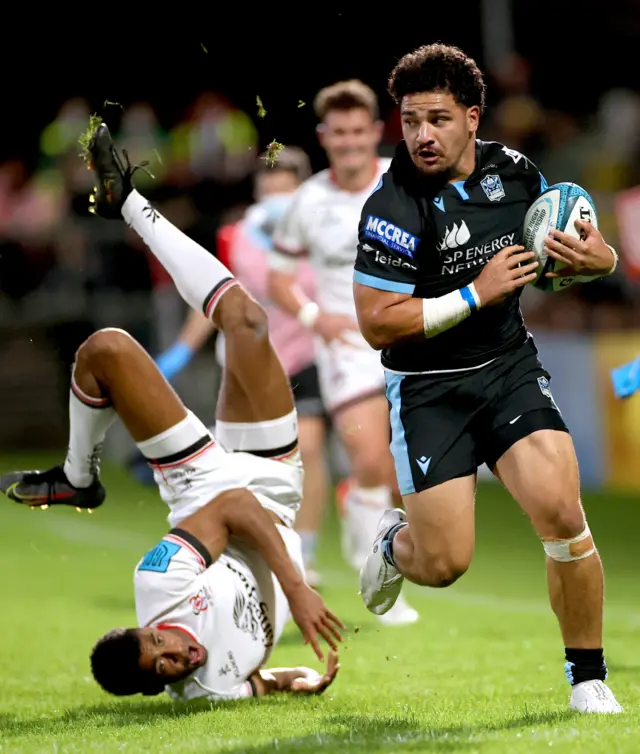 Ulster's Robert Baloucoune is bowled over by Glasgow's Sione Tuipulotu