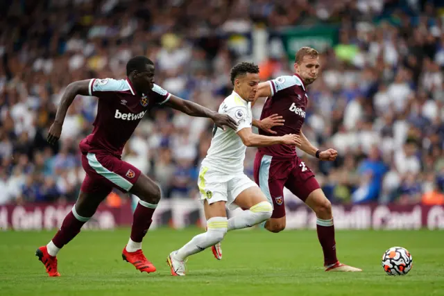 Leeds United's Raphinha (centre) is challenged by West Ham United's Jarrod Bowen and Kurt Zouma