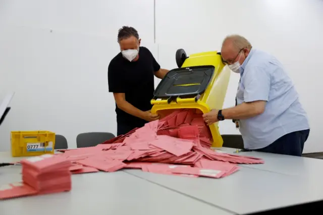 Election workers prepare the mailed-in ballot letters during the German general elections