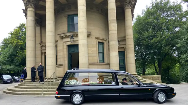 Hearse with coffin pulling up outside Saltaire United Reformed Church