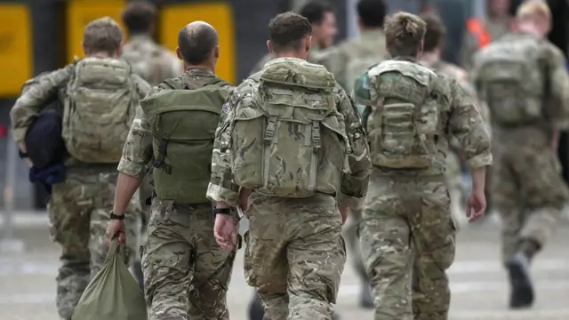 Members of the British armed forces 16 Air Assault Brigade walk to the air terminal after disembarking a RAF Voyager aircraft