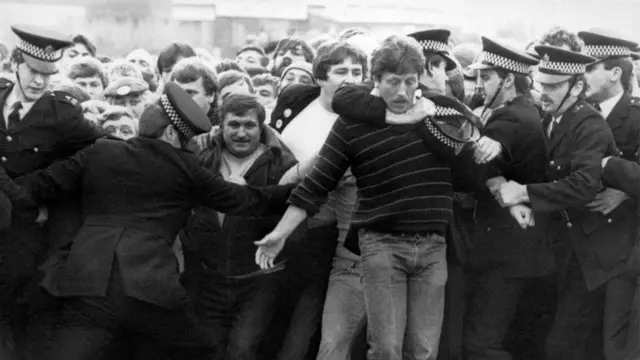 Police restrain picketers outside a pit during the miners' strike