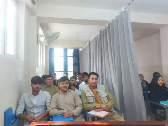 Male and female students sit separately at university in Kabul