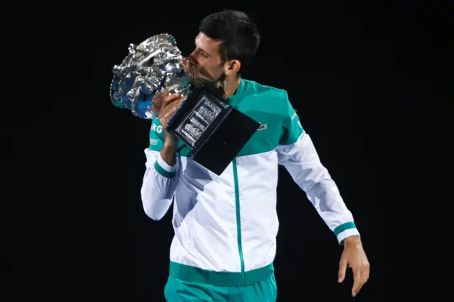 Serbia's Novak Djokovic kisses the Norman Brookes Challenge Cup trophy after beating Russia's Daniil Medvedev to win their men's singles final match on day fourteen of the Australian Open tennis tournament in Melbourne on February 21, 2021.