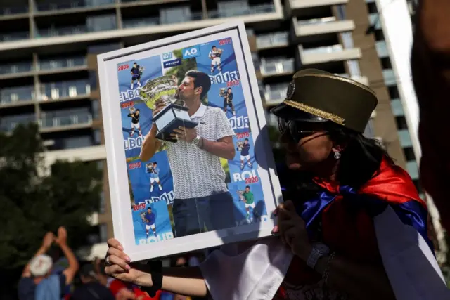 A fan holds a picture of Novak Djokovic