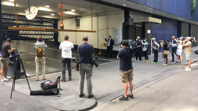 A crowd of reporters have stationed themselves outside Djokovic's lawyers' office, where the tennis player is rumoured to be headed after court proceedings adjourned.