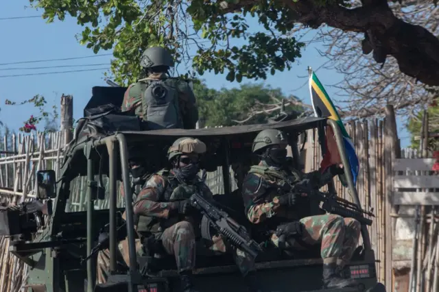 A military convoy of South Africa National Defence Forces (SANDF) rides along a dirt road in the Maringanha district in Pemba on August 5, 2021