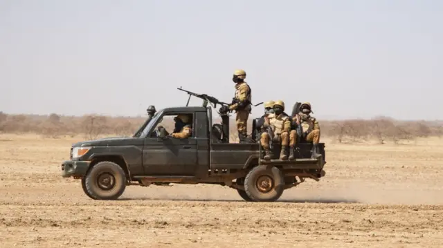 Burkina Faso soldiers patrol aboard a pick-up truck on the road from Dori to the Goudebo refugee camp, on February 3, 2020