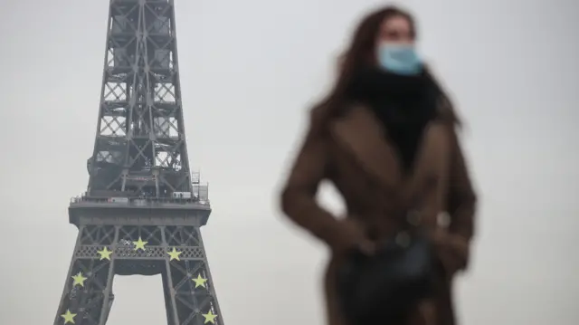 Woman walking by the Eiffel Tower in Paris