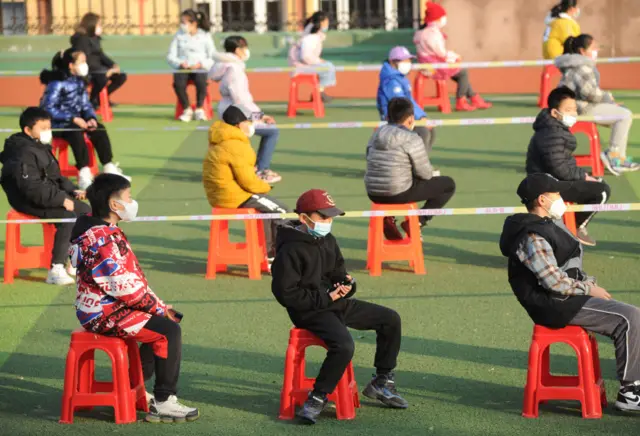 Students queue for Covid-19 nucleic acid test at a school in Dalian, Liaoning province, China, on 5 December 2021