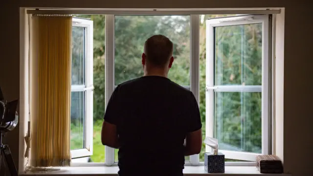 Man standing alone by a window