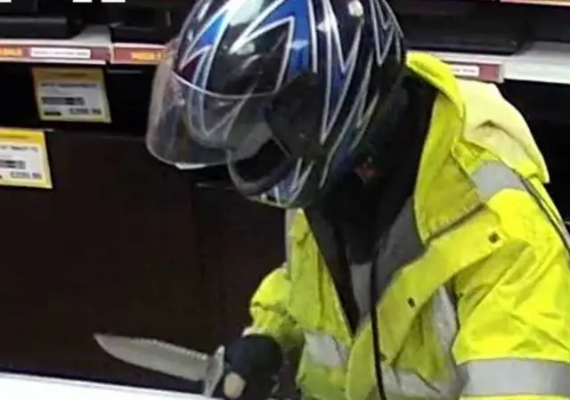 CCTV image of man in helmet with knife