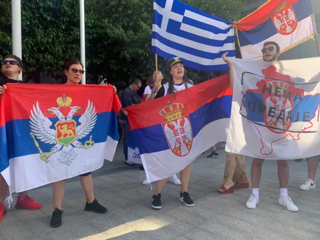 Supporters hold flags outside court after the decision