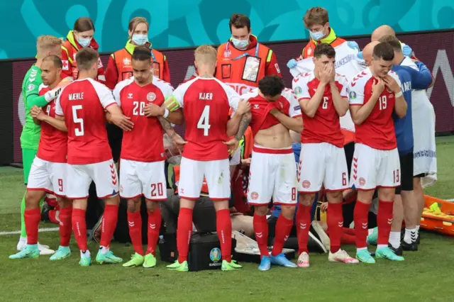 Denmark players shield Christian Eriksen