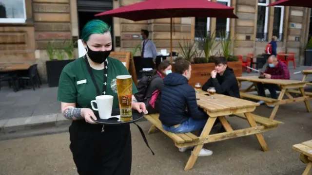 Hospitality worker carries drinks