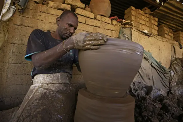 A potter making a clay pot in Omdurman, Sudan - Wednesday 19 January 2022