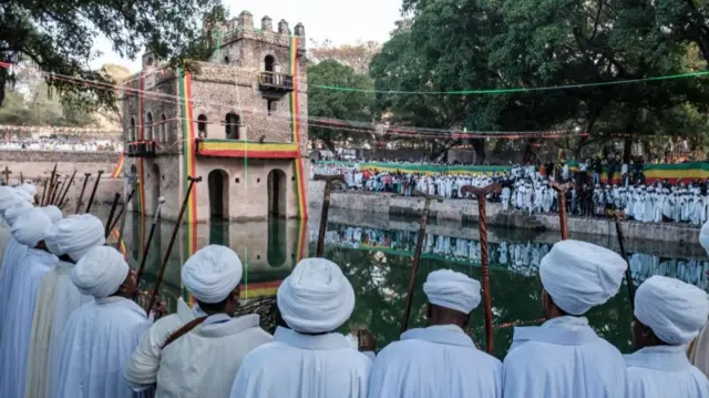 Ethiopian Orthodox priests stand next to the pool of Fasilides Bath during the celebration of Timkat, the Ethiopian Epiphany, in the city of Gondar, Ethiopia, on January 19, 2022