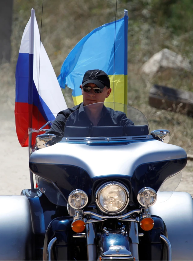 Russian President Vladimir Putin rides a Harley Davidson decorated with Russian and Ukrainian flags in Crimea back in 2010