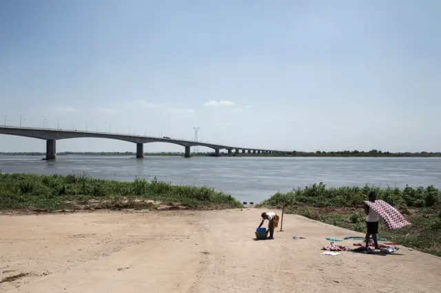 Women dry and fold their clothes on the edge of the Zambezi River in central Mozambique on December 9, 2015.