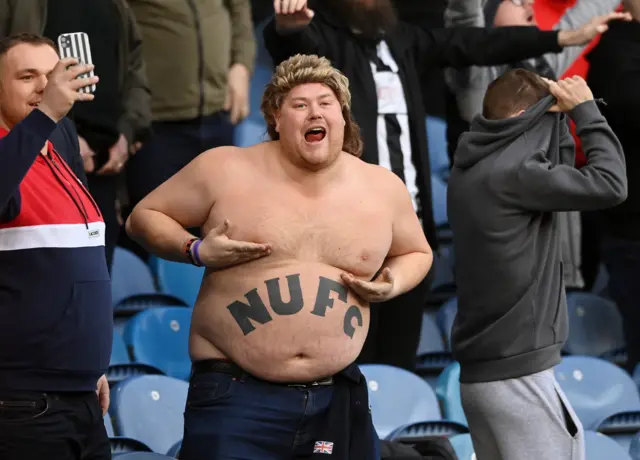 Newcastle fan with no top on and NUFC tattoo on his stomach