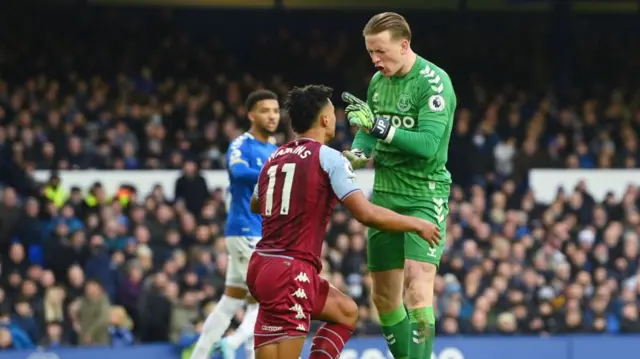 Jordan Pickford of Everton confronts Ollie Watkins