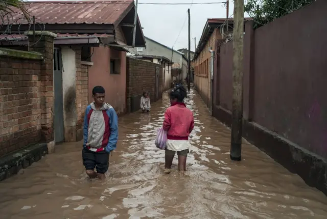 Madagascans walk amidst flooding from a tropical cyclone in the neighborhood of Ankorondrano Andranomahery in the capital Antananarivo, Madagascar, 23 January 2022