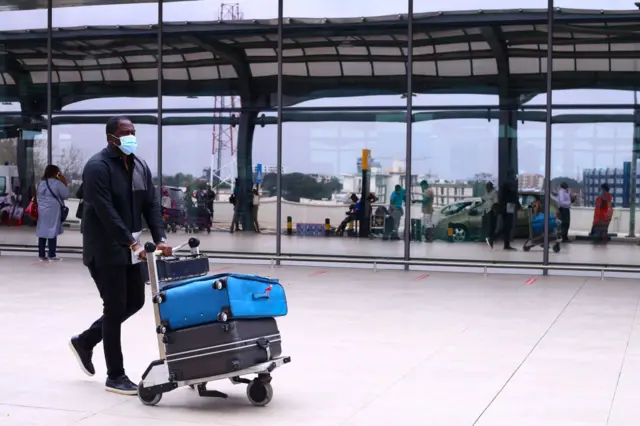 A man pushing luggage on a trolley at Kotoka International Airport in Accra, Ghana -  in 2020