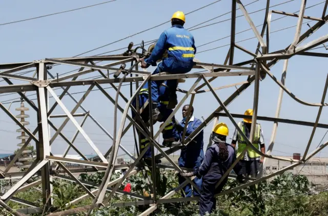 Technicians work on a collapsed high voltage electricity transmission pylons in a district of Nairobi, Kenya - 12 January 2022