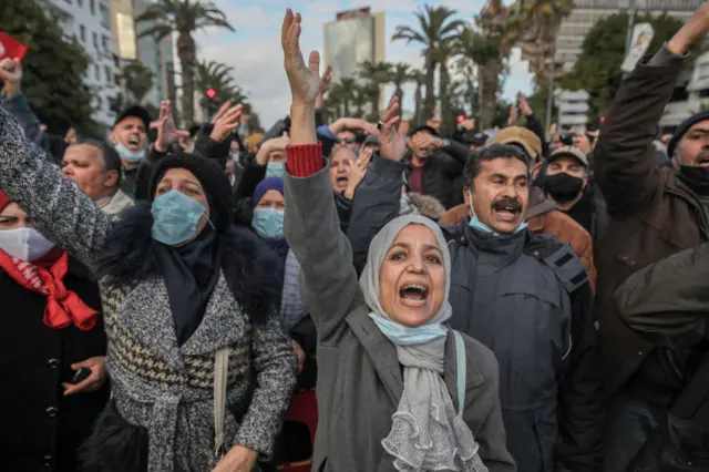 Tunisian protesters gesture as they shout Dégage, get out, during a demonstration held on the occasion of the 11th anniversary of the fall of late Tunisian president Zine El Abidine Ben Ali.