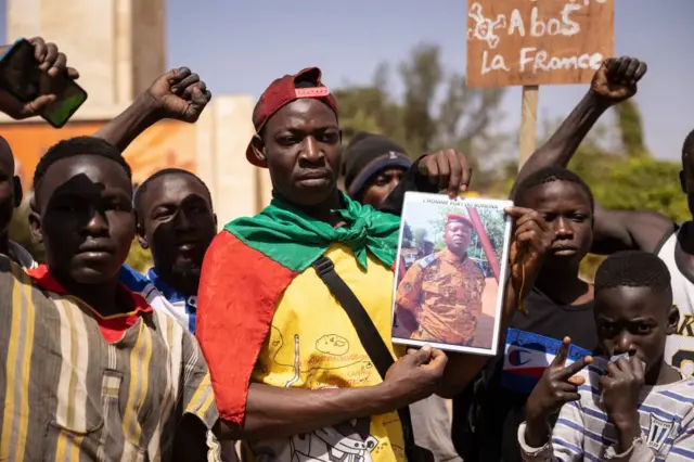 Demonstrators gather in Ouagadougou to show support to the military hold a picture of Paul-Henri Sandaogo Damiba the leader of the mutiny