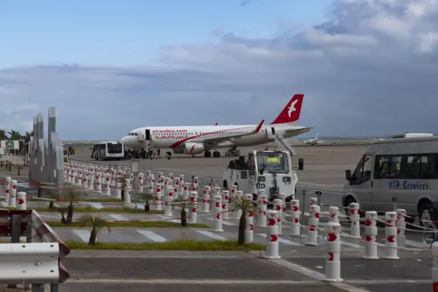 Air Arabia Maroc Airbus A320 aircraft as seen at Fes - Sais Airport near the city of Fez while passenger are seen boarding the plane.