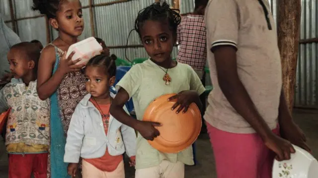 Children, who fled the violence in Ethiopia's, Tigray region, wait in line for breakfast organized by a self-volunteer Mahlet Tadesse, 27, in Mekelle, the capital of Tigray region, on 23 June 2021