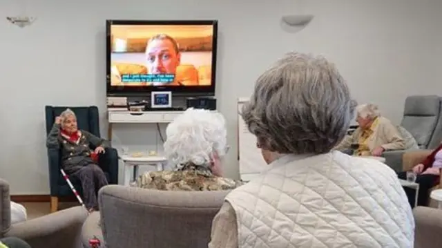 Care home residents watching TV