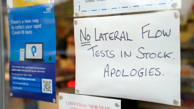 A sign warning that take away lateral flow test kits are out of stock on the window of a pharmacy in Colden Common, Hampshire.