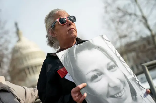 Ashli Babbitt's mum holds a picture of her