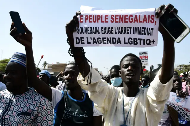 A man holds a sign reading 'No to LGBT agenda' during a protest called by religious associations against homosexuality on May 23, 2021, on the Obelisque square in Dakar.