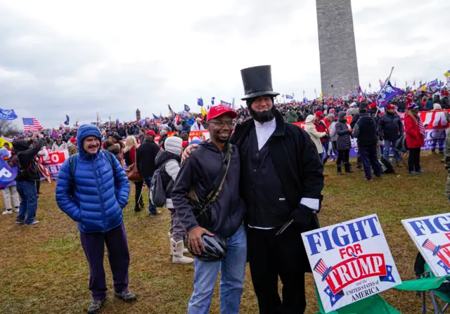 A man dressed as former US president Abraham Lincoln takes pictures with pro-Trump protestors on 6 January 2021