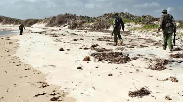 Armed police men patrol a stretch of beach near Lamu, Kenya - 2011