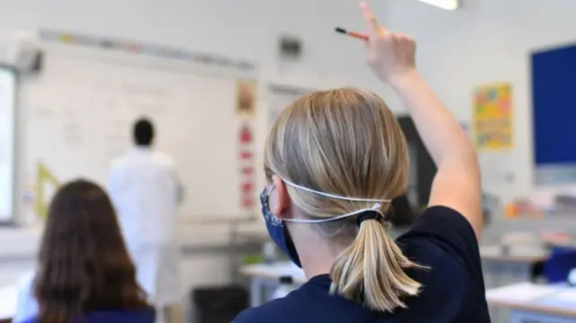 Stock image of pupil wearing mask in a classroom